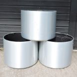A set of three brushed aluminium style garden pots,