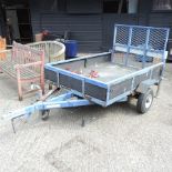 A blue painted metal car trailer, with stabilising legs and spare tyre,