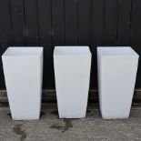 A set of three white garden pots,