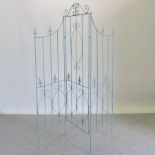 A metal folding garden screen, with three panels,