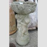 A reconstituted stone cherub bird bath,