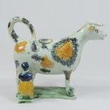 An early 19th century Prattware type cow and milkmaid creamer,