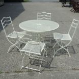 A white painted metal folding garden table and matching chairs