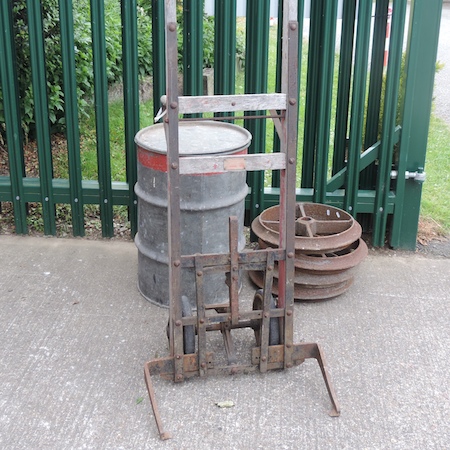 A vintage drum trolley, together with a drum, containing sacks,