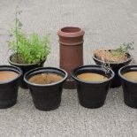 A set of six black glazed plant pots, together with a chimney pot,