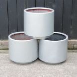 A set of three silver painted garden pots,