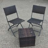 A pair of rattan folding garden chairs, together with a matching coffee table,