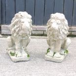 A pair of reconstituted stone models of seated lions,
