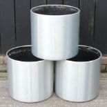 A set of three brushed aluminium coloured garden pots,