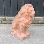 A terracotta statue of a seated lion,