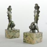 A pair of Art Deco silvered brass bookends, in the form of stylised birds,