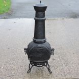 A black painted cast iron chiminea, relief decorated with vines,