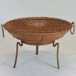 A metal firepit and grill, on stand,