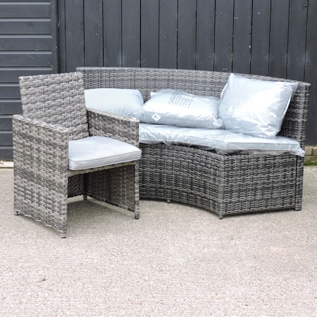 A grey rattan curved sofa, 180cm, together with a small armchair,