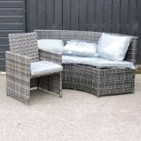 A grey rattan curved sofa, 180cm, together with a small armchair,