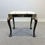 An early 20th century black chinoiserie decorated footstool,