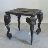 An early 20th century Indian carved hardwood occasional table, on elephant supports,