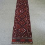 A Turkish woollen runner, with six medallions, on a red ground,
