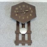 An Arts and Crafts oak wall clock,