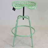 A green painted metal tractor seat stool