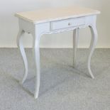 A cream painted pine side table, containing a single drawer,