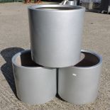 A set of three silver painted garden pots,