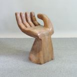 A carved hardwood seat, in the form of a hand,