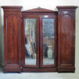 A Victorian mahogany wardrobe, enclosed by a pair of mirrored doors,