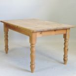 A pine kitchen table, on turned legs,