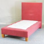 A red upholstered single bedstead, handmade by Savoir Beds,