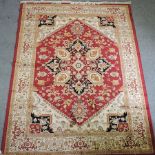 A Heriz style rug, with a central medallion and foliate designs, on a red field,