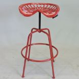 A red painted metal tractor seat stool