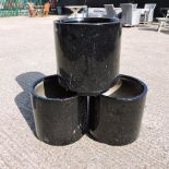 A set of three black painted garden pots,