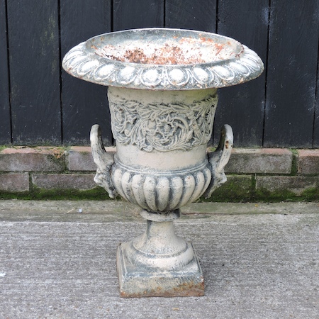 A Victorian white painted cast iron urn, with lion mask relief,
