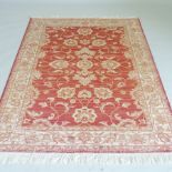 A Ziegler style rug, with all over foliate design, on a red ground,