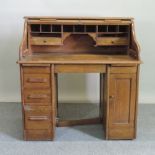 An Edwardian oak desk, with a tambour front,