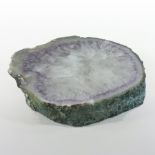 A polished geode plinth, with clear, purple and grey inclusions,