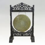 A Chinese brass gong, on a carved hardwood stand,