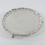 An Edwardian Scottish silver salver, of circular shape with a piecrust border, on three hoof feet,