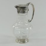 A Victorian silver mounted glass claret jug, having a floral relief decorated spout,