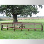 A pair of mahogany benches, of large proportions, each having open arms and a solid seat,