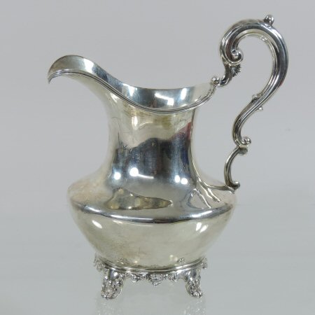 A large William IV silver cream jug, of baluster shape, with a scrolled handle,