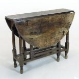 A 17th century oak gateleg dining table, with a hinged circular top, on turned legs,