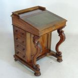 A Victorian walnut Davenport, having an inset green leather writing surface,