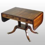 A Regency rosewood, crossbanded and boxwood strung sofa table, with a hinged rectangular top,