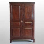 A George III mahogany double wardrobe, enclosed by a pair of panelled doors, on bracket feet,