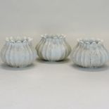 A set of three carved marble garden planters, each of flowerhead shape,