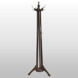 An Edwardian walnut coat stand, with a rotating top, on a tripod base,