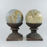 A pair of marble and cast iron lawn markers, each of ball shape,