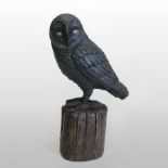 A bronze model of an owl, perched on a rock,
